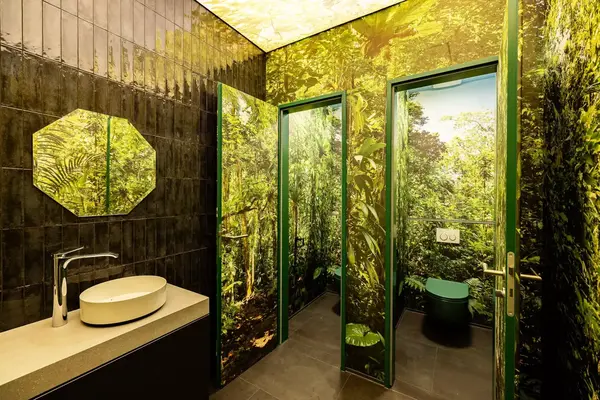 Modernes Badezimmer mit Dschungelmotiv, grüne Pflanzenmuster an Wänden und Türen.